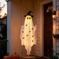 White hanging ghost with a black witch hat and bat prints glowing on a front porch
