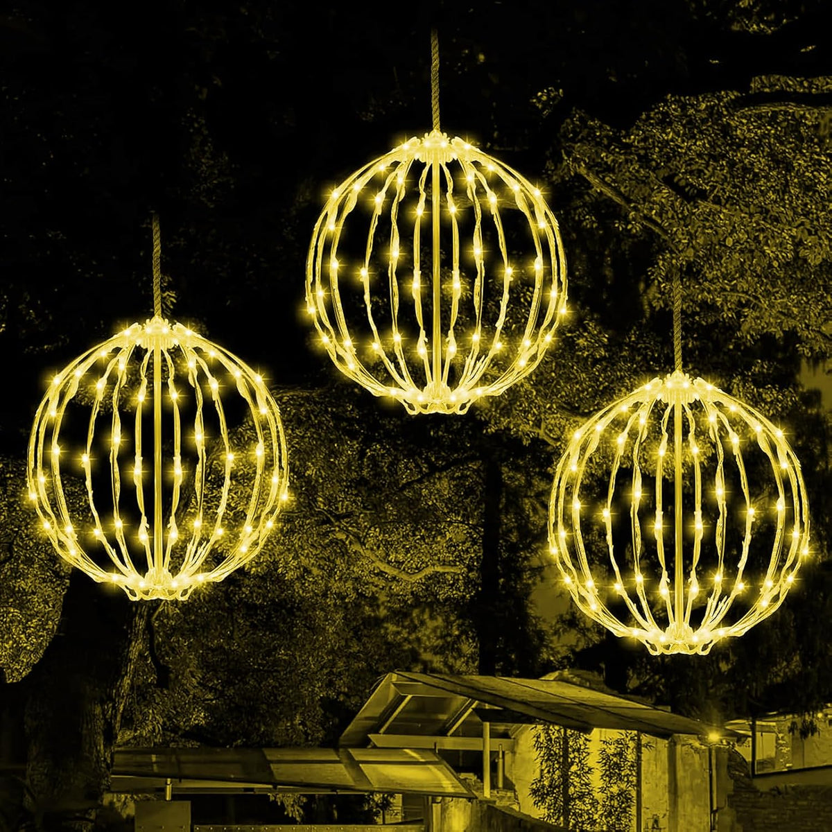 Three warm white light balls hanging at different heights from a tree at night