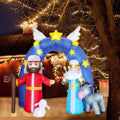 Nativity inflatable with Mary, Joseph, a donkey and a lamb under a blue starry arch with angel wings