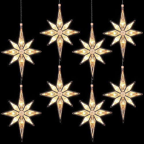 Several warm white Bethlehem star lights hanging on cords against a black background